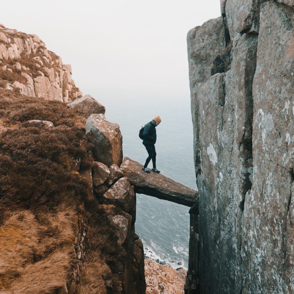 man hiking standing on a rock